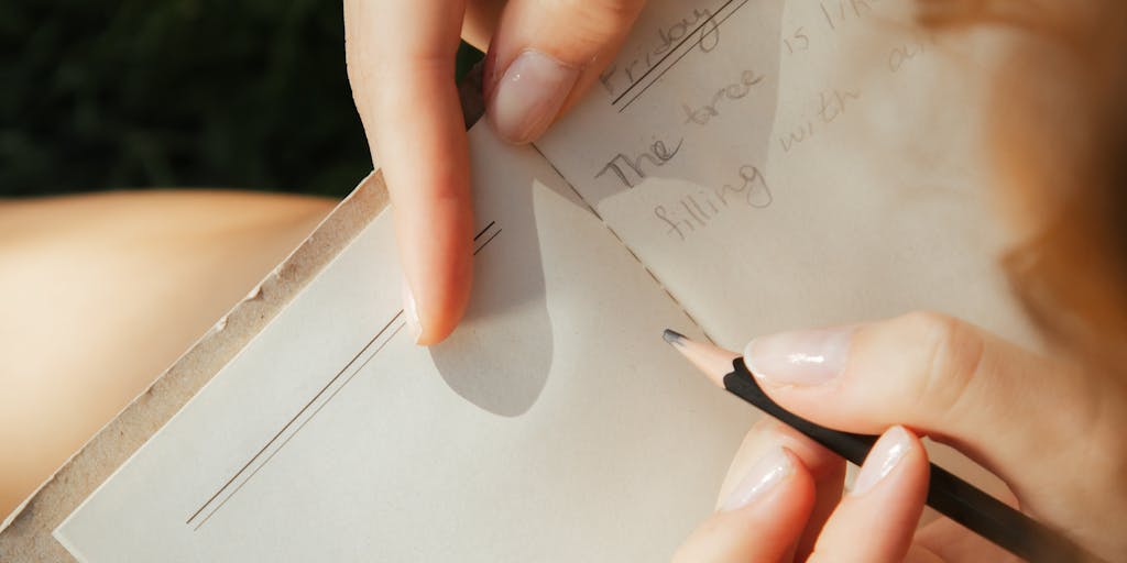 A person sitting in a park, typing on a laptop with a serene nature backdrop. The screen displays a 'Wordtune Alternative' interface, while the person is deep in thought, with a notepad and pen beside them, illustrating the blend of technology and inspiration from nature.