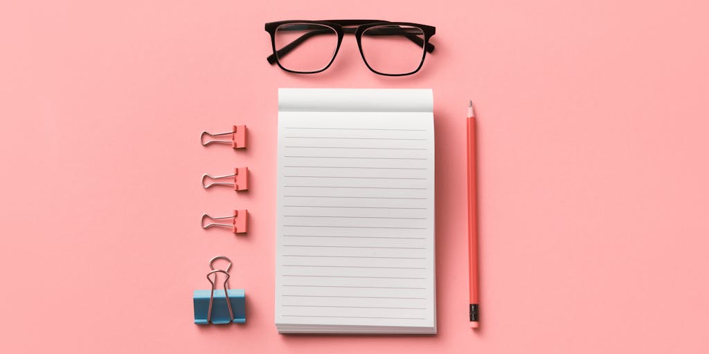 An overhead shot of a desk cluttered with various writing tools (notebooks, pens, sticky notes) on one side, and a clean, minimalist workspace with a laptop displaying a free AI writing tool on the other side. This juxtaposition emphasizes the simplicity of using AI alternatives.