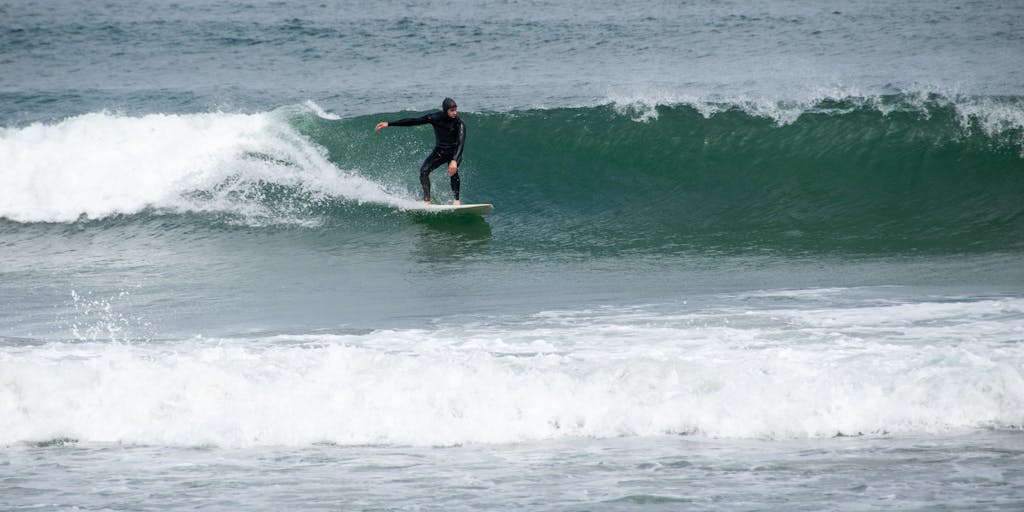 A split image showing a surfer riding a wave on one side and a digital marketer analyzing data on a laptop on the other. The surfer is in vibrant colors, while the marketer is surrounded by graphs and charts, symbolizing the contrast between the physical and digital worlds.