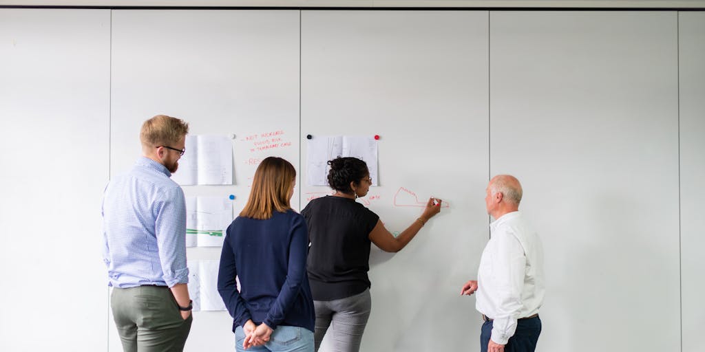 A dynamic image of a diverse group of people in a brainstorming session, with a large screen displaying Vista Social analytics. The group is engaged and animated, showcasing collaboration and the power of social media insights.