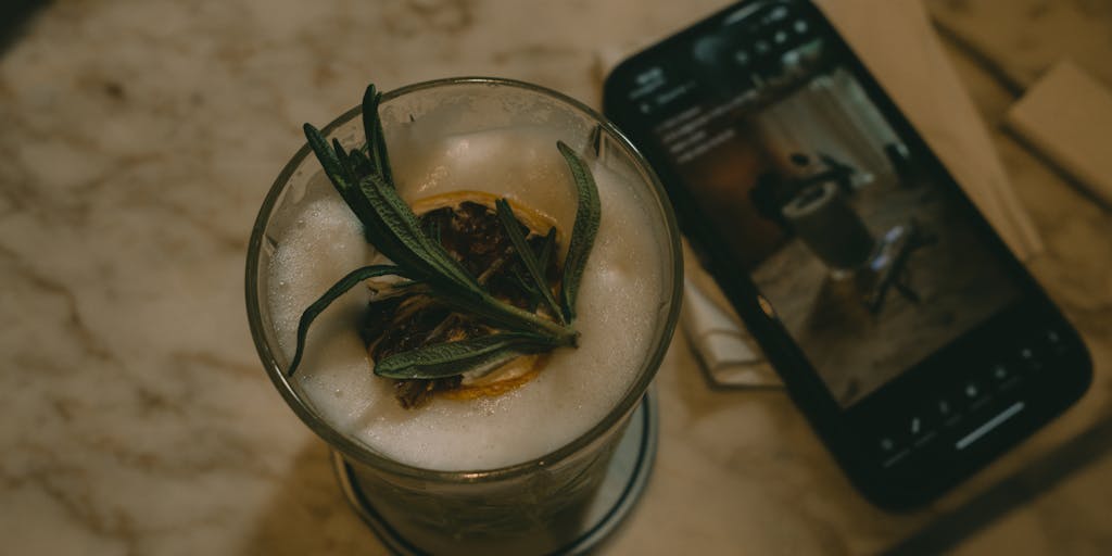 An overhead shot of a person using SocialBee on a tablet while sitting in a cozy café. The table is adorned with a notebook, a pen, and a small plant, creating a warm and inviting atmosphere that highlights the ease of managing social media on the go.