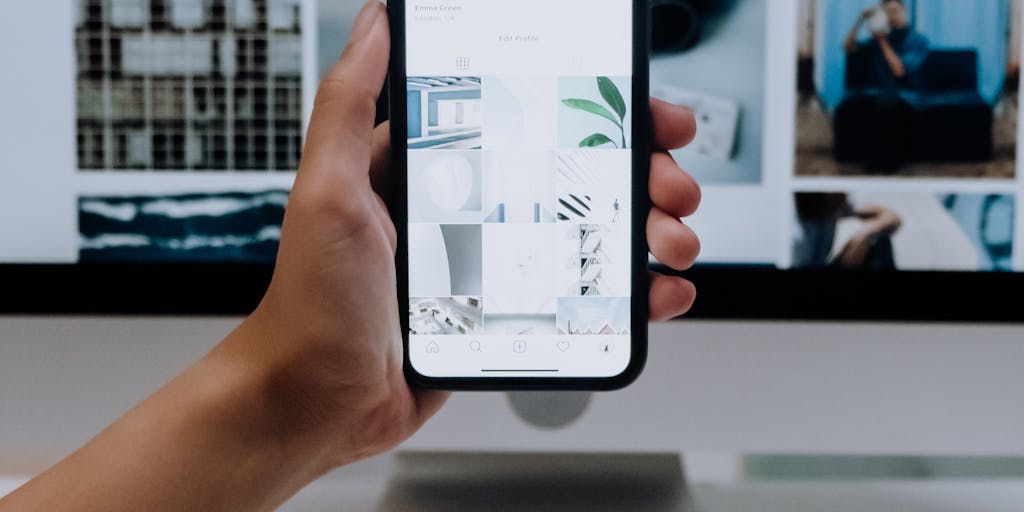 A dynamic action shot of a person engaging with both platforms simultaneously on two different devices. Capture the excitement of multitasking, with one hand on the laptop using Zoho Social and the other on a smartphone using Publer. The background can be a lively coffee shop to convey a modern, on-the-go vibe.