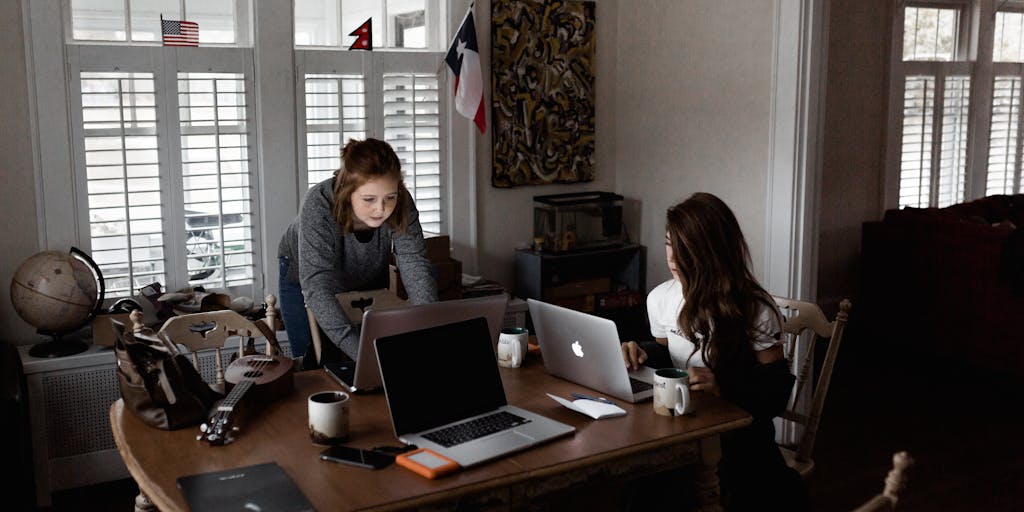 An overhead shot of two coffee cups on a table, each labeled with 'Buffer' and 'Metricool'. Between them, a notepad with pros and cons written down for each tool. The scene is cozy and inviting, suggesting a brainstorming session about which tool to choose for social media management.