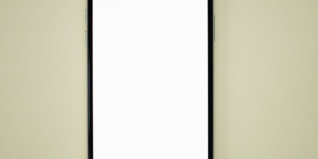 A close-up shot of two smartphones side by side, each displaying the mobile interface of ContentStudio and SocialPilot. The phones are placed on a wooden table with coffee cups and notepads around them, suggesting a casual brainstorming session. The focus is on the screens, showcasing the apps in action.