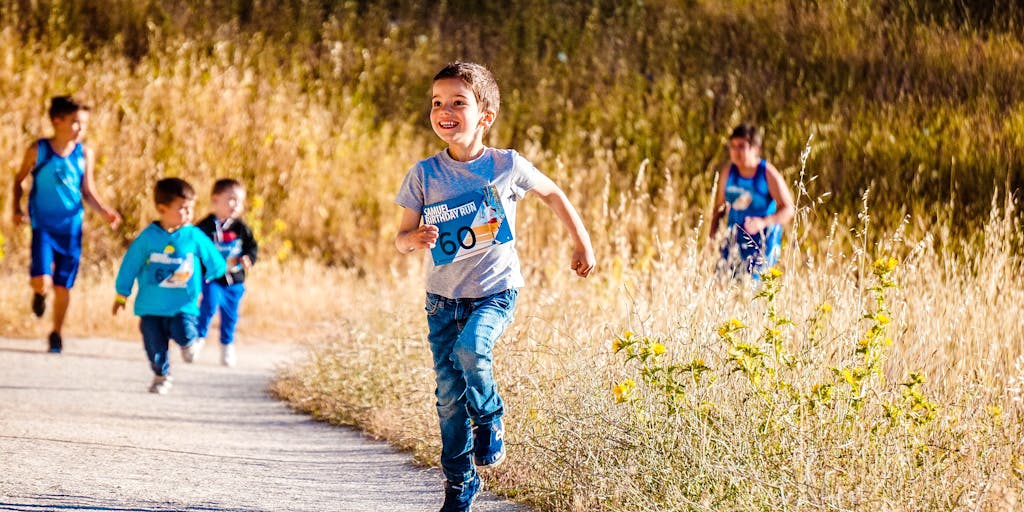 A whimsical scene depicting a race between two runners, one wearing a Metricool jersey and the other in an Agorapulse jersey. They are sprinting down a track lined with social media logos, with a finish line banner that reads 'Social Media Management Showdown'.