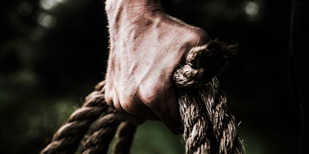 An artistic representation of a tug-of-war between two teams, one wearing Zoho Social branded gear and the other in Vista Social attire. The rope symbolizes the competition between the two platforms, with social media icons scattered around to emphasize the theme.
